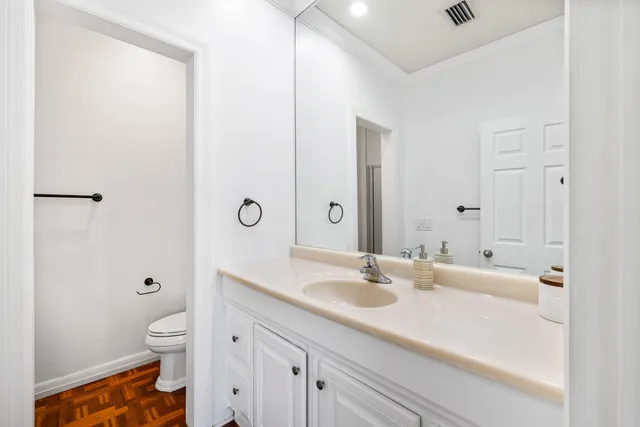 a bathroom with a granite countertop sink a toilet and shower