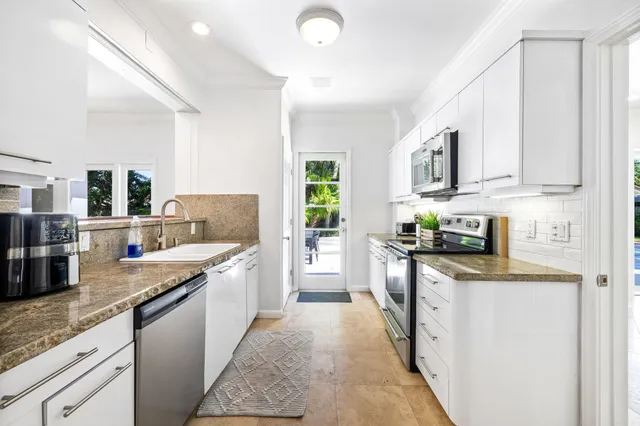 a kitchen with stainless steel appliances granite countertop a stove top oven a sink dishwasher and a refrigerator