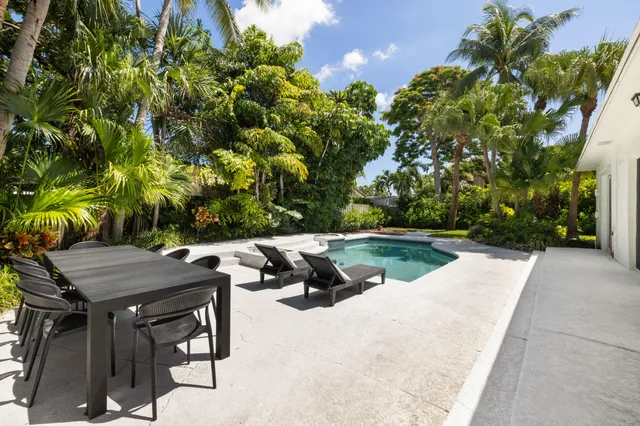 a view of backyard with swimming pool and outdoor seating