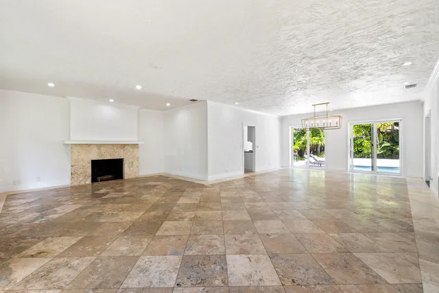 a view of an empty room with a fireplace and a window