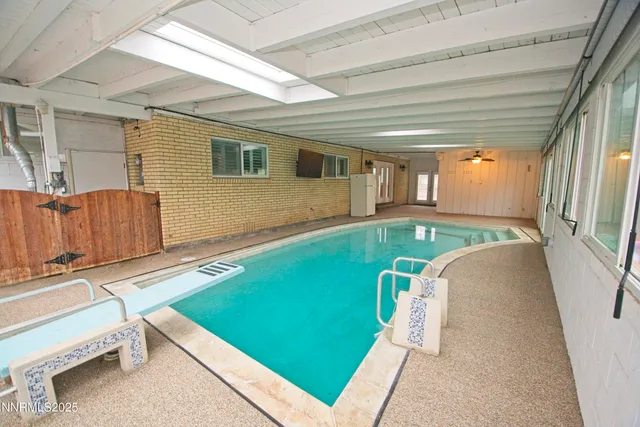 a room with pool table and windows