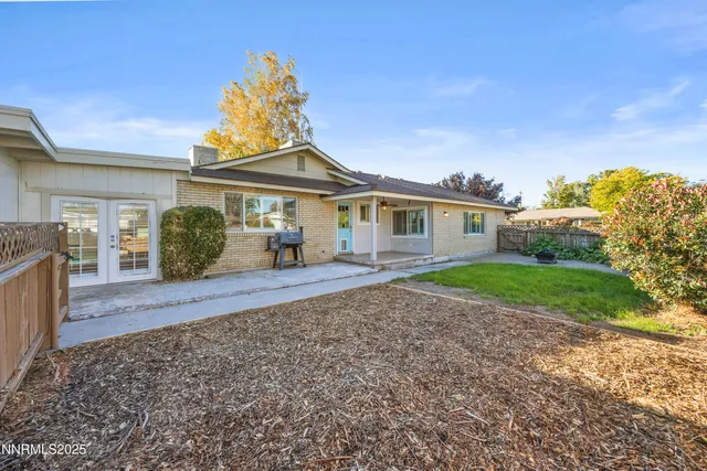 a front view of a house with a yard and potted plants