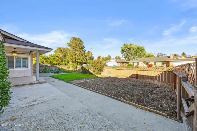 a view of a yard with wooden fence