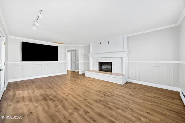 a view of empty room with wooden floor and fireplace