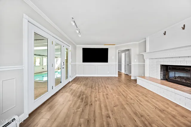 a view of empty room with wooden floor and fireplace