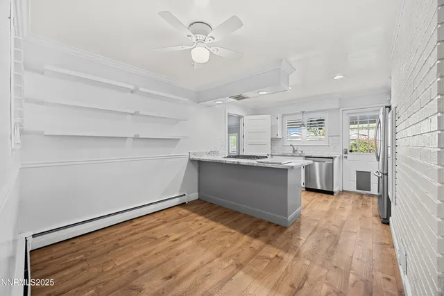 a kitchen with stainless steel appliances kitchen island a refrigerator sink and cabinets