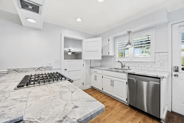 a kitchen with granite countertop a stove a sink dishwasher and a refrigerator