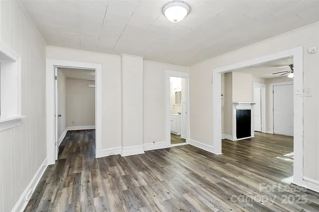 a view of a livingroom with wooden floor and staircase