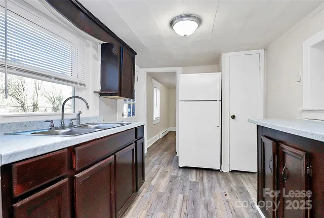 a kitchen with a sink cabinets and wooden floor