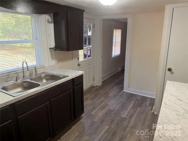 a kitchen with a sink and wooden floor