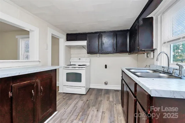 a kitchen with a sink stove top oven and cabinets