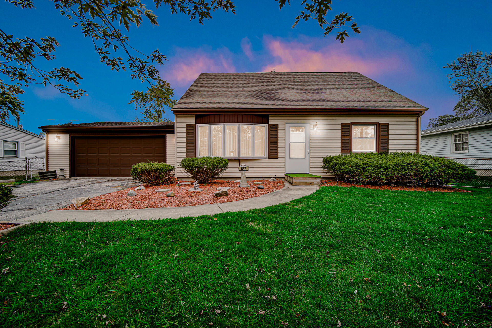 a front view of a house with a yard and potted plants