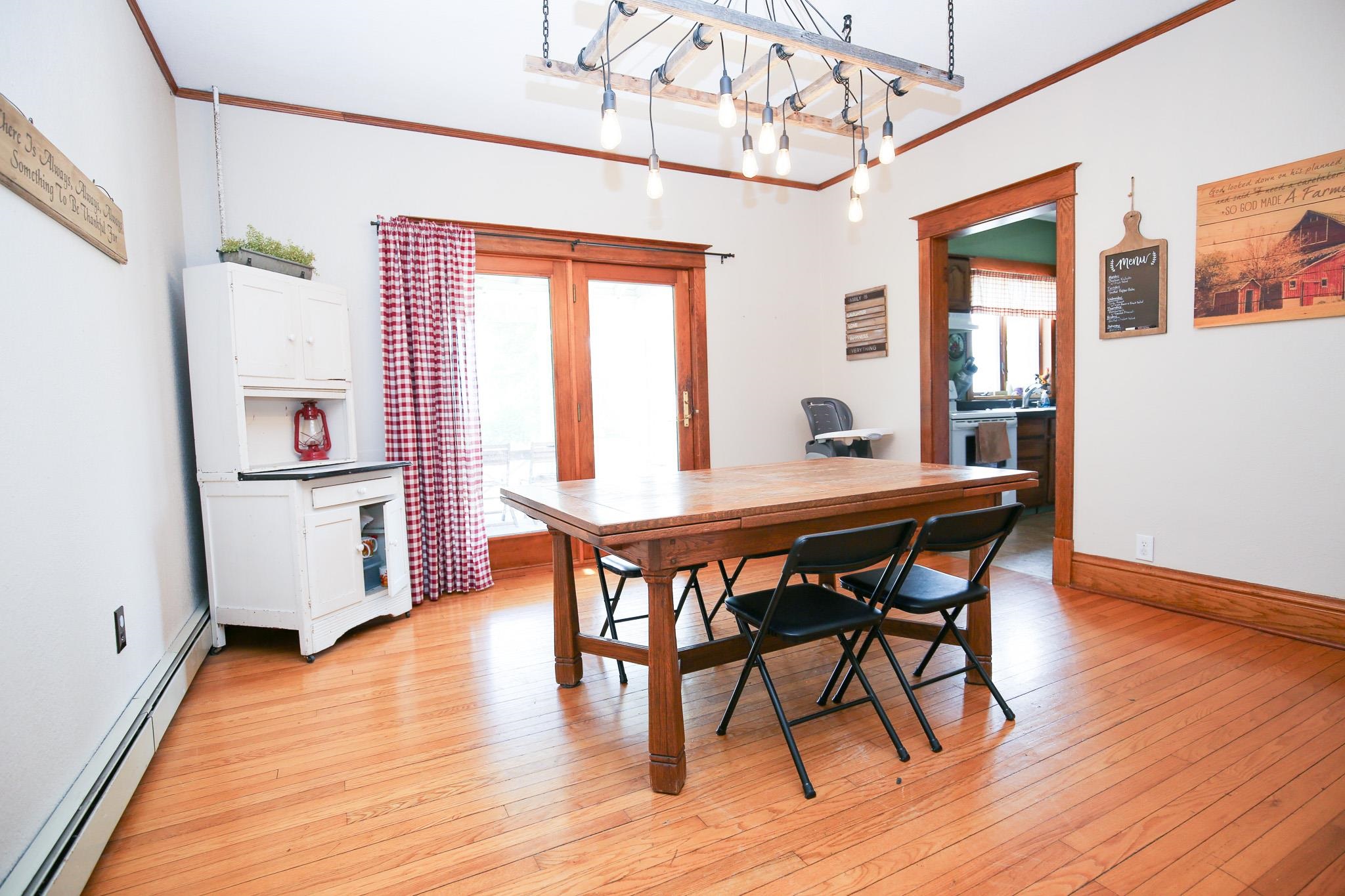 1905 Melugins Grove Road Rochelle, IL 61068 - Photo 5 of 36 a dining room with wooden floor a chandelier a wooden table and chairs