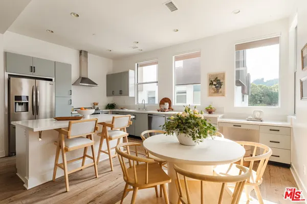 a kitchen with stainless steel appliances kitchen island granite countertop a dining table and chairs