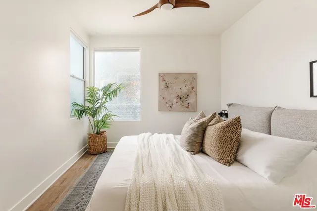 a bedroom with a large bed and a potted plant