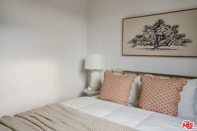 a bedroom with a bed and painting on the wall