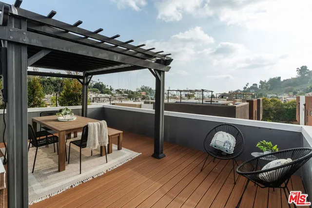 a balcony with wooden floor and outdoor seating