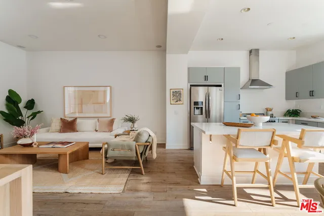 a living room with furniture and a dining table with kitchen view