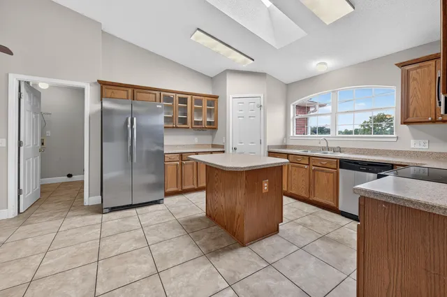 a kitchen with stainless steel appliances granite countertop a refrigerator and a stove top oven