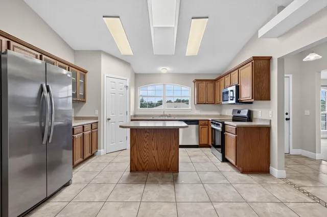 a kitchen with stainless steel appliances granite countertop a stove a sink and a microwave