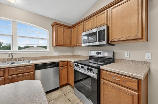 a kitchen with stainless steel appliances granite countertop a sink and a stove
