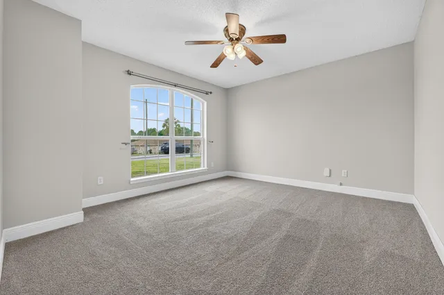 an empty room with chandelier fan