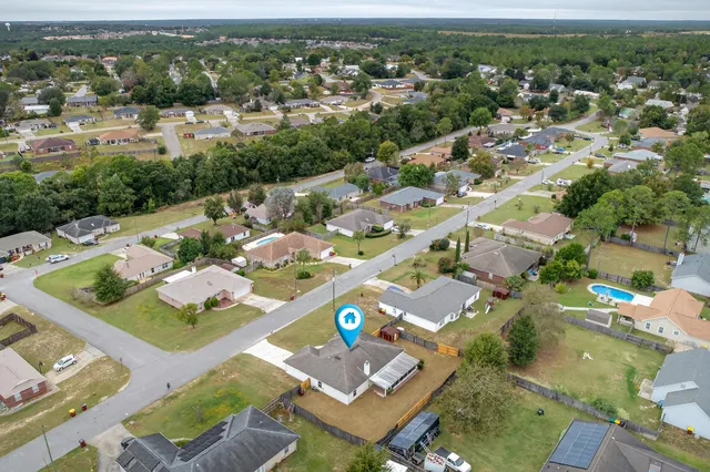 a view of a house with a backyard and a tree