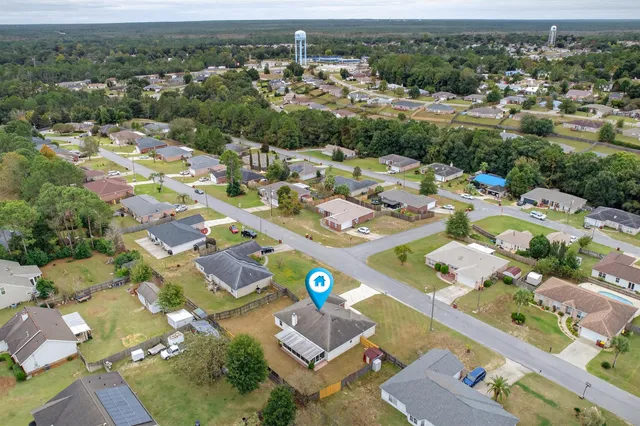 a view of a house with backyard and trees