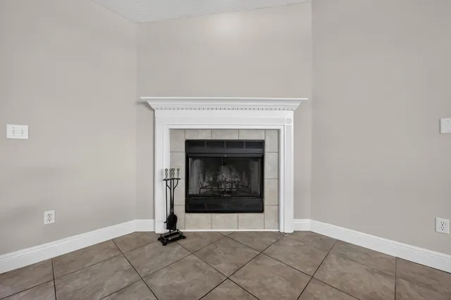 an empty room with windows and fireplace