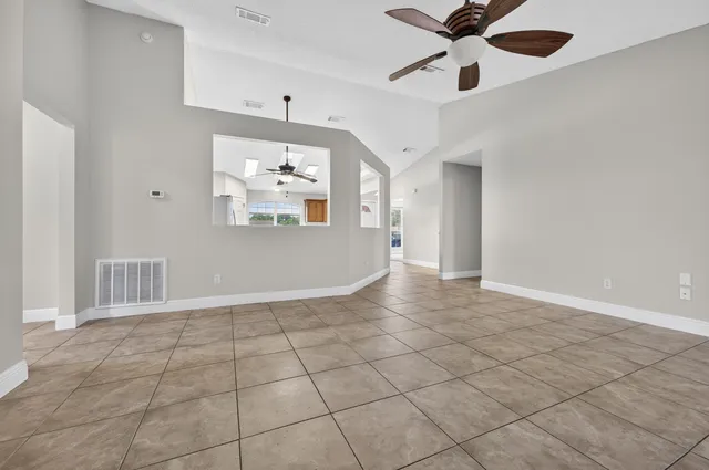 a view of an empty room with window and cabinet