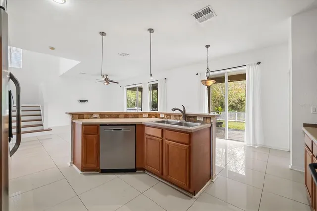 a kitchen with kitchen island a counter top space appliances and a window
