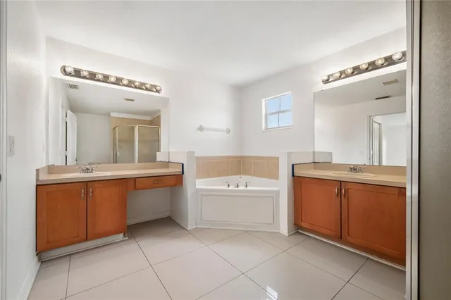 a spacious bathroom with a granite countertop sink mirror and bathtub