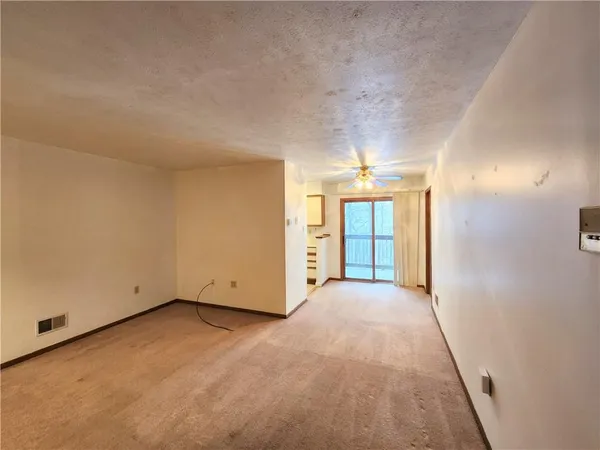 en empty room with windows and cabinet