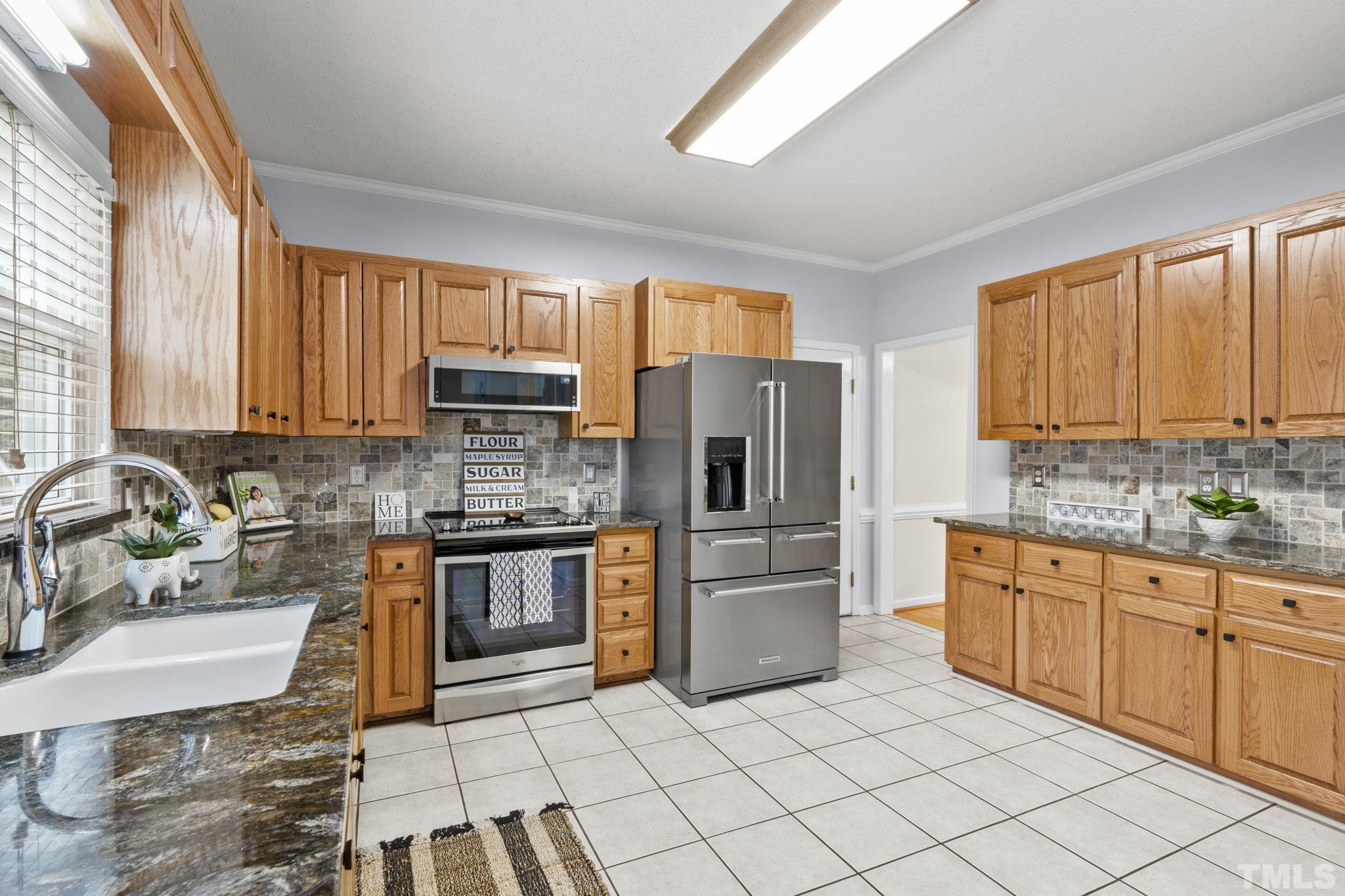 1101 Sky Point Court Raleigh, NC 27603 - Photo 12 of 52 a kitchen with stainless steel appliances granite countertop a stove top oven a sink dishwasher a refrigerator and a microwave