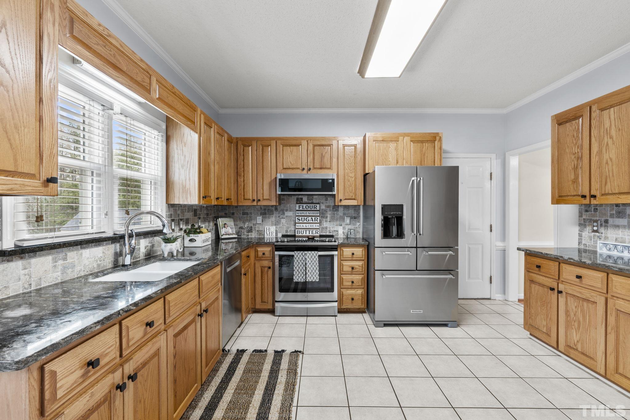 1101 Sky Point Court Raleigh, NC 27603 - Photo 13 of 52 a large kitchen with stainless steel appliances granite countertop a stove a sink and a microwave