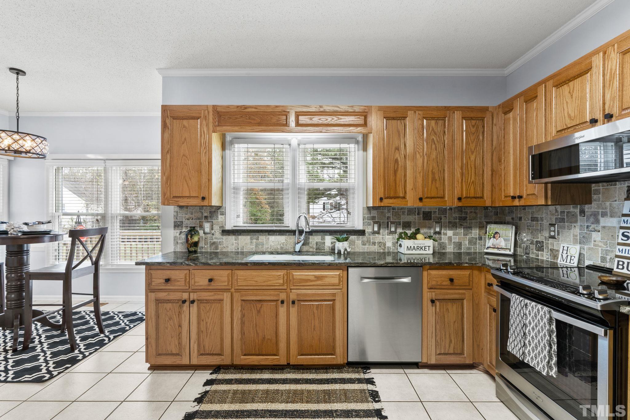 1101 Sky Point Court Raleigh, NC 27603 - Photo 14 of 52 a kitchen with stainless steel appliances granite countertop a stove a sink and a microwave