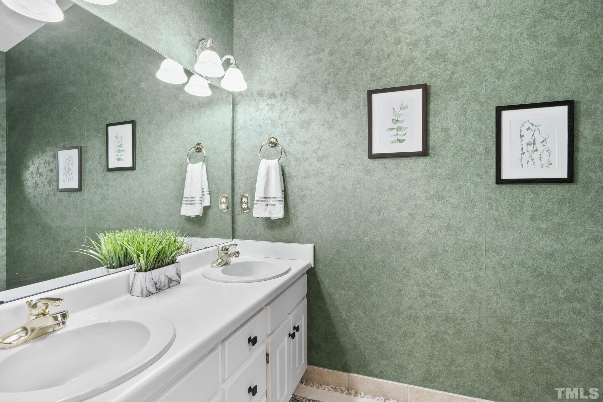 1101 Sky Point Court Raleigh, NC 27603 - Photo 27 of 52 a bathroom with a double vanity sink and a mirror