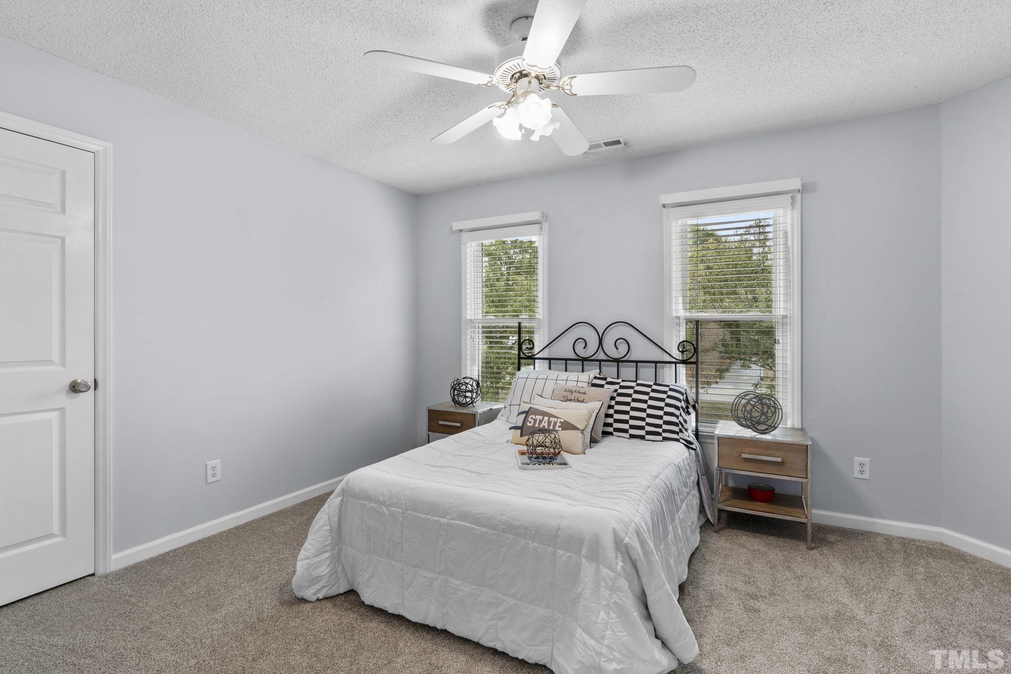 1101 Sky Point Court Raleigh, NC 27603 - Photo 29 of 52 a bedroom with a large bed and a chandelier