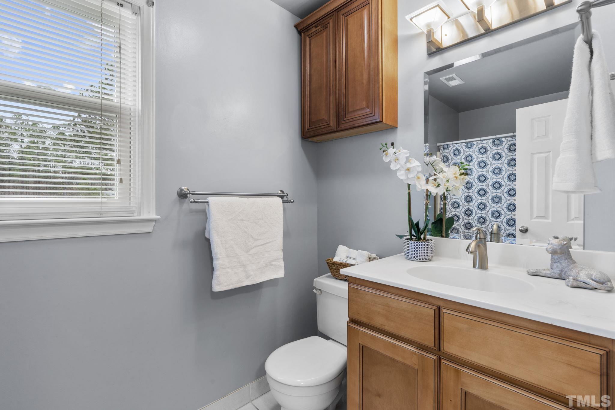 1101 Sky Point Court Raleigh, NC 27603 - Photo 30 of 52 a bathroom with a granite countertop sink toilet and mirror