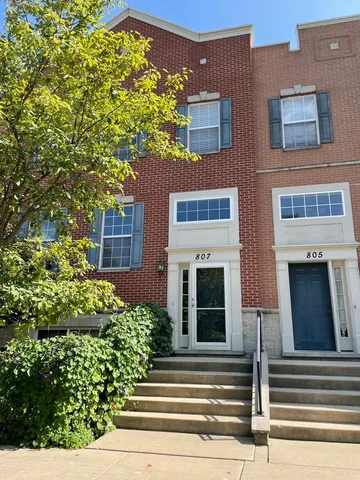 a view of a house with potted plants and a fountain
