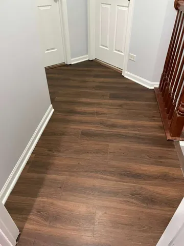 a view of an empty room with wooden floor