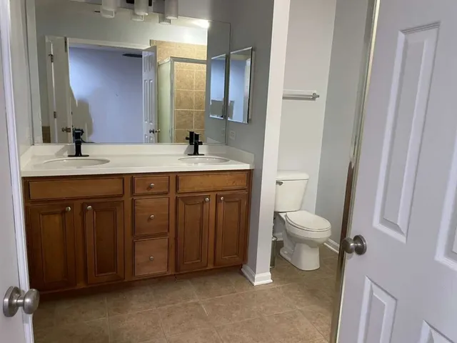 a spacious bathroom with a toilet sink and mirror