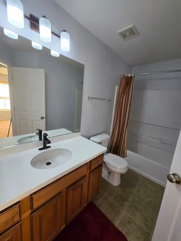 a bathroom with a sink a toilet and mirror