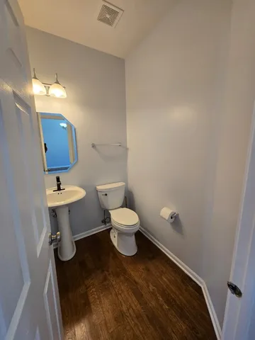 a bathroom with a toilet a sink and mirror