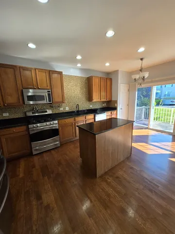 a kitchen with stainless steel appliances wooden floors and wooden cabinets