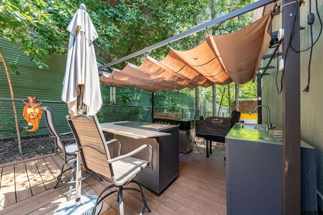 a view of a patio with a table chairs and a barbeque
