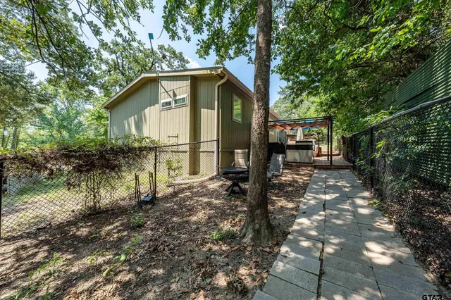 a backyard of a house with barbeque oven table and chairs in a yard