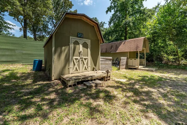 a backyard of a house with barbeque oven table and chairs
