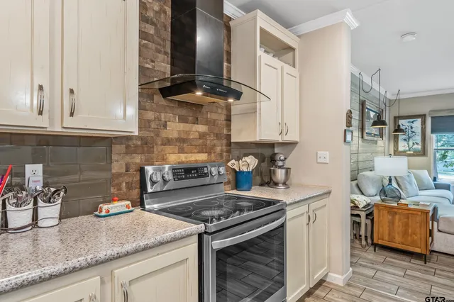 a kitchen with granite countertop a sink a stove and cabinets
