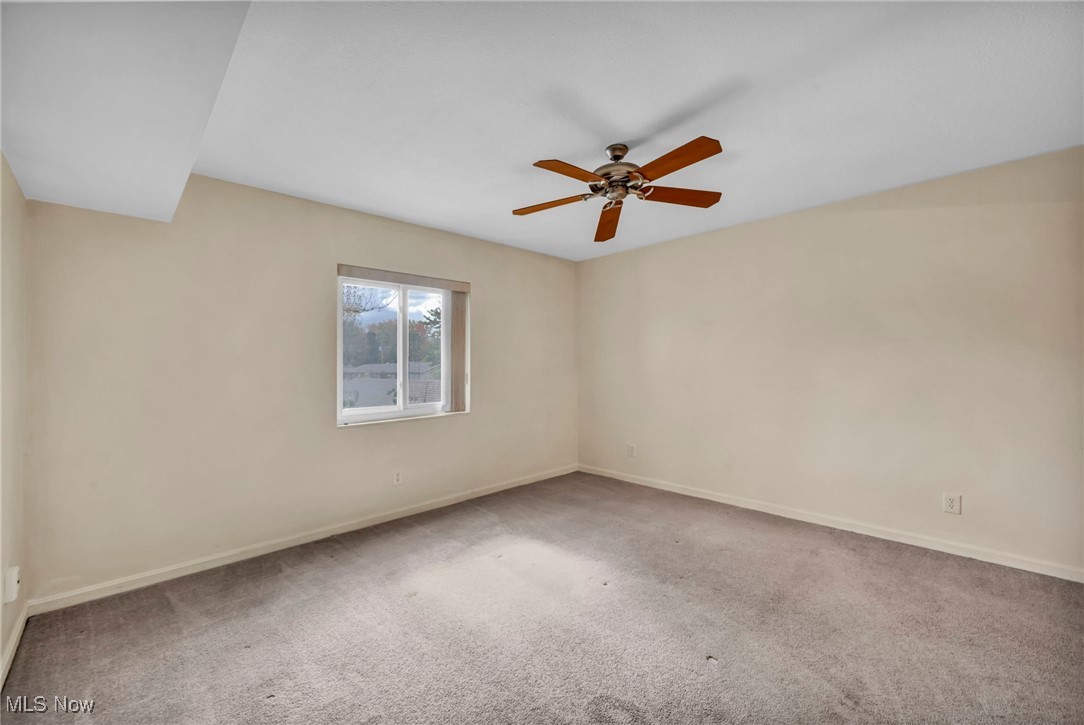 1263 Lost Nation Road, Unit 5 Willoughby, OH 44094 - Photo 18 of 26 Spare room featuring light carpet and a ceiling fan